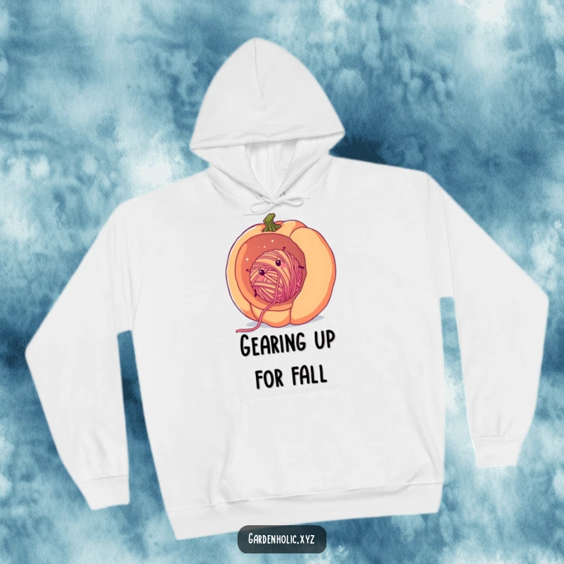Funny cozy yarn hoodie showing a cheerful, fuzzy ball of yarn rolling downhill inside a giant pumpkin, perfect for warm relaxation.